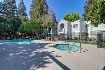A swimming pool surrounded by a fence and trees.